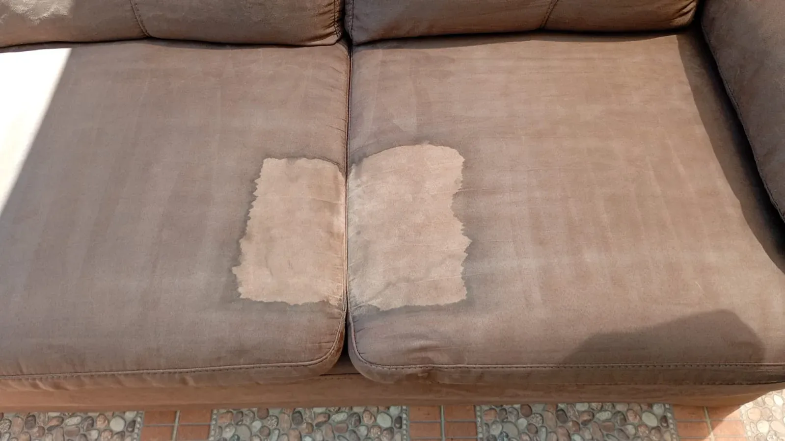 Cojín de sillón en tela café con dos zonas ya lavadas